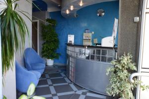 a waiting room with a blue counter and plants at Hotel Ženeva in Kragujevac