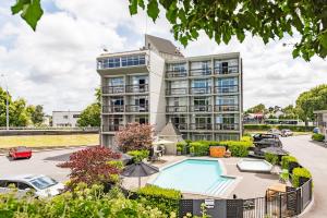 an apartment building with a pool and a parking lot at Heartland Ambassador Hotel Hamilton in Hamilton