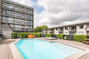 a large swimming pool in front of a building at Heartland Ambassador Hotel Hamilton in Hamilton