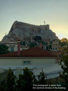 a castle on top of a hill behind a city at Adrianou 150 in Athens