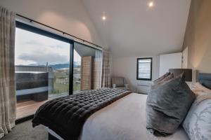 a bedroom with a large glass window with a bed and a view at 4 Stockyard Lane in Queenstown