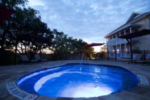 a large blue pool with a fountain in a yard at Gruene River Hotel & Retreat in New Braunfels