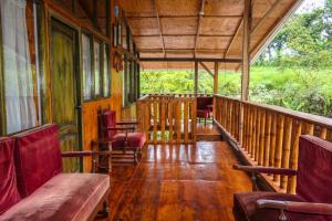 a porch of a train cabin with chairs and tables at Mindoxtrem Birds in Mindo