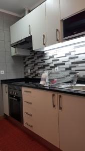 a kitchen with a sink and a stove at Ninho 0.1 in Vila Nova de Gaia