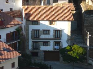 une vue aérienne sur un bâtiment blanc avec des toits de tuiles rouges dans l'établissement Apartamentos El Pajar Alcala de la Selva, à Alcalá de la Selva