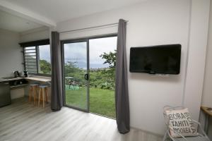 a living room with a flat screen tv on a wall at Ocean view & spa in Punaauia