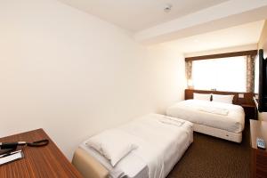 Postel nebo postele na pokoji v ubytování Sotetsu Fresa Inn Tokyo Tamachi