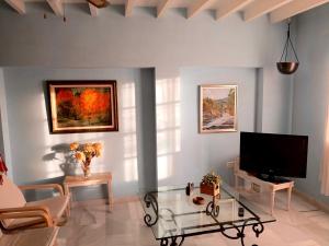 a living room with a tv and a glass table at Los Bancales in Frigiliana