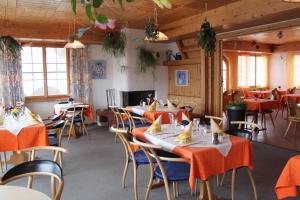 un comedor con mesas y sillas con mantel naranja en Hotel Gravas Lodge - Das Hotel für Gäste mit Hund, en Vella