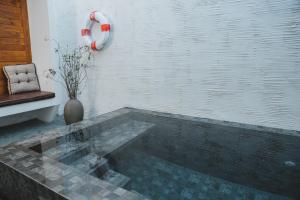 uma piscina de água num quarto com uma cadeira em Arun Dara Villa em Chiang Mai
