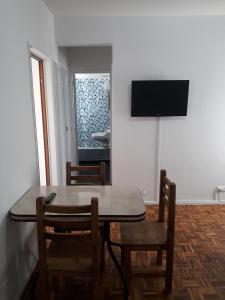 comedor con mesa, sillas y TV en Aquí Departamentos en Buenos Aires