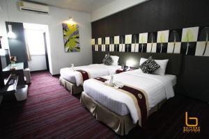 A bed or beds in a room at Baiyoke Boutique Hotel