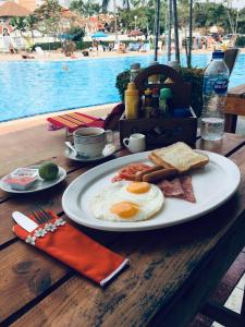 a plate of breakfast food on a table next to a pool at B&B View Talay 1B Apartments Pattaya in Pattaya South