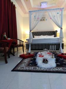 a bedroom with a bed and a table with candles at Tafadal in Ibrā
