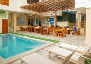 a pool in a restaurant with people sitting at tables at Hostal España in Puerto Ayora