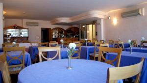 a dining room with blue tables and chairs at Hotel Feluca in Bonassola