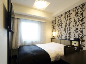 a bedroom with a bed and a window at APA Hotel Asakusa Kaminarimon in Tokyo