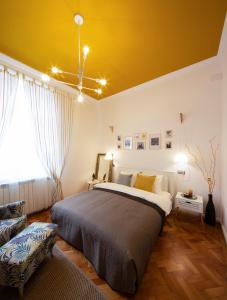 a bedroom with a large bed and a yellow ceiling at Yellow Apartment in Cluj-Napoca