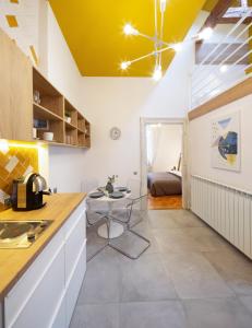 a kitchen with a counter and a table in a room at Yellow Apartment in Cluj-Napoca