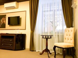 Habitación con TV, silla y ventana. en Bon Ami Hotel, en Kazán