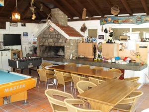 a kitchen with tables and chairs and a fireplace at Villa Majer in Preko