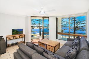 a living room with a couch and a tv at Eastbourne U4 80 Esplanade Golden Beach in Caloundra