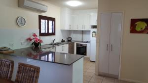 
a kitchen with a refrigerator, stove, sink and dishwasher at Nautilus Holiday Apartments in Port Douglas
