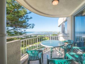 a balcony with a table and chairs and a view of the ocean at Seaspray U4 21 Warne Tce in Caloundra
