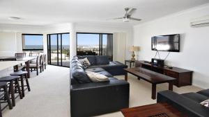 a living room with a black couch and a table at Amalfi Unit 11 Above All Else 50 King Street in Caloundra