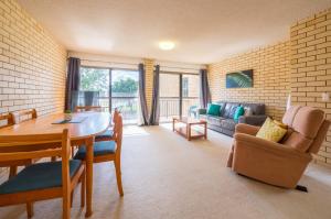a living room with a table and a couch at Golden Shores Unit 3 21 Landsborough Parade in Caloundra