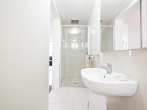 a white bathroom with a sink and a shower at Pacific Towers Unit 4, 19 Ormonde Tce Kings Beach in Caloundra