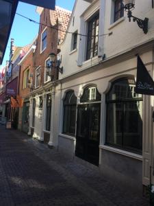 a cobblestone street in a city with buildings at Hotel 't Fnidsen in Alkmaar