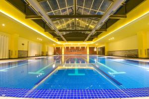 a large swimming pool in a building at Infinitea Tea Garden Resort in Pālampur