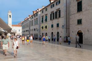 un grupo de personas caminando en una calle frente a los edificios en Studio Stradun, en Dubrovnik