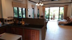 Una cocina con encimera y una sala de estar. en Periwinkle Villa, en Ko Chang