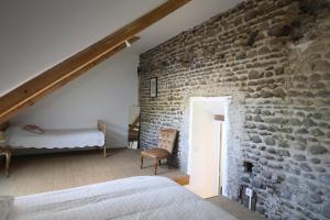 - une chambre avec un mur en pierre et un lit dans une pièce dans l'établissement Domaine Lacay, à Beyrie-en-Béarn