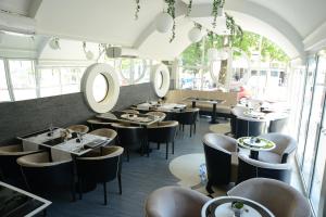 a restaurant with tables and chairs and windows at Hotel Ženeva in Kragujevac
