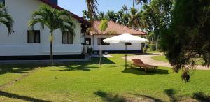 una silla y una sombrilla frente a una casa en Acquabey Surf Villa, en Matara