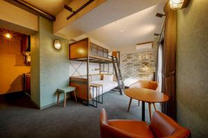 um quarto de hotel com um beliche, uma mesa e cadeiras em RESI STAY BRiX em Quioto