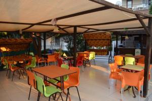 un patio al aire libre con mesas, sillas, mesas y sillas en Ahmeda Apart Hotel, en Ayvalık