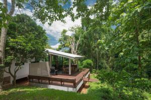a house in the woods with a deck at Montira Coffee & Tea Estate Mae Kampong in Ban Pong