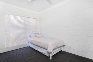 een witte kamer met een bed en een raam bij Booker Pde 34 Unit 2 Pet Friendly in Pelican Waters