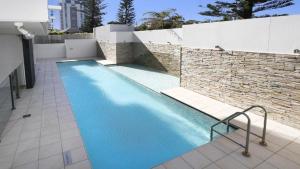 a swimming pool with blue water in a building at Amalfi Unit 11 Above All Else 50 King Street in Caloundra