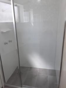 a shower with a glass door in a bathroom at Moondara Unit 2 21 Bulcock Beach Esplanade Bulcock Beach in Caloundra +5 photos
