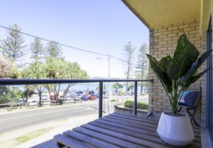 a porch with a bench and a plant on a balcony at Moondara Unit 2 21 Bulcock Beach Esplanade Bulcock Beach in Caloundra