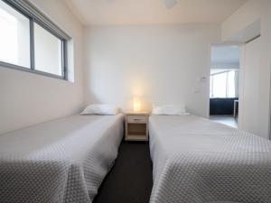 two beds sitting next to each other in a room at Pacific Towers Unit 4 19 Ormonde Tce Kings Beach in Caloundra