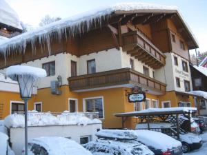 ein großes Gebäude mit Eiszapfen im Schnee in der Unterkunft Gasthof zum Kaiserweg in Schladming