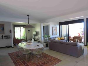 a living room with a couch and a table at Villa 'Florence' avec longue piscine et vue mer panoramique in Saint-Gilles les Bains