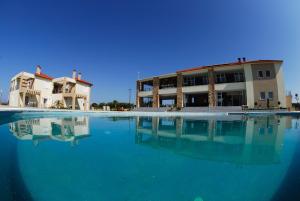 a large pool of water in front of a building at Antonios Village Hotel & Apartments in Arkoudi