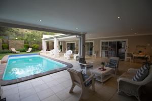 a swimming pool in a house with chairs and a table at House on Olof Palme in Windhoek